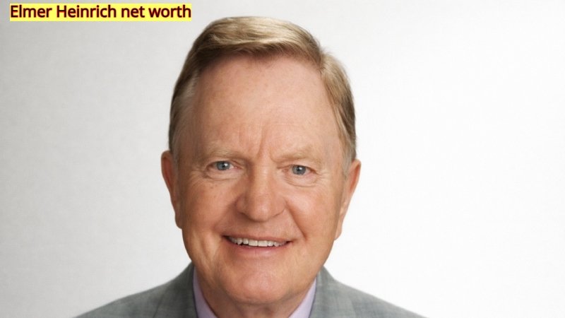 Elmer Heinrich smiling in a suit showcasing his success and net worth